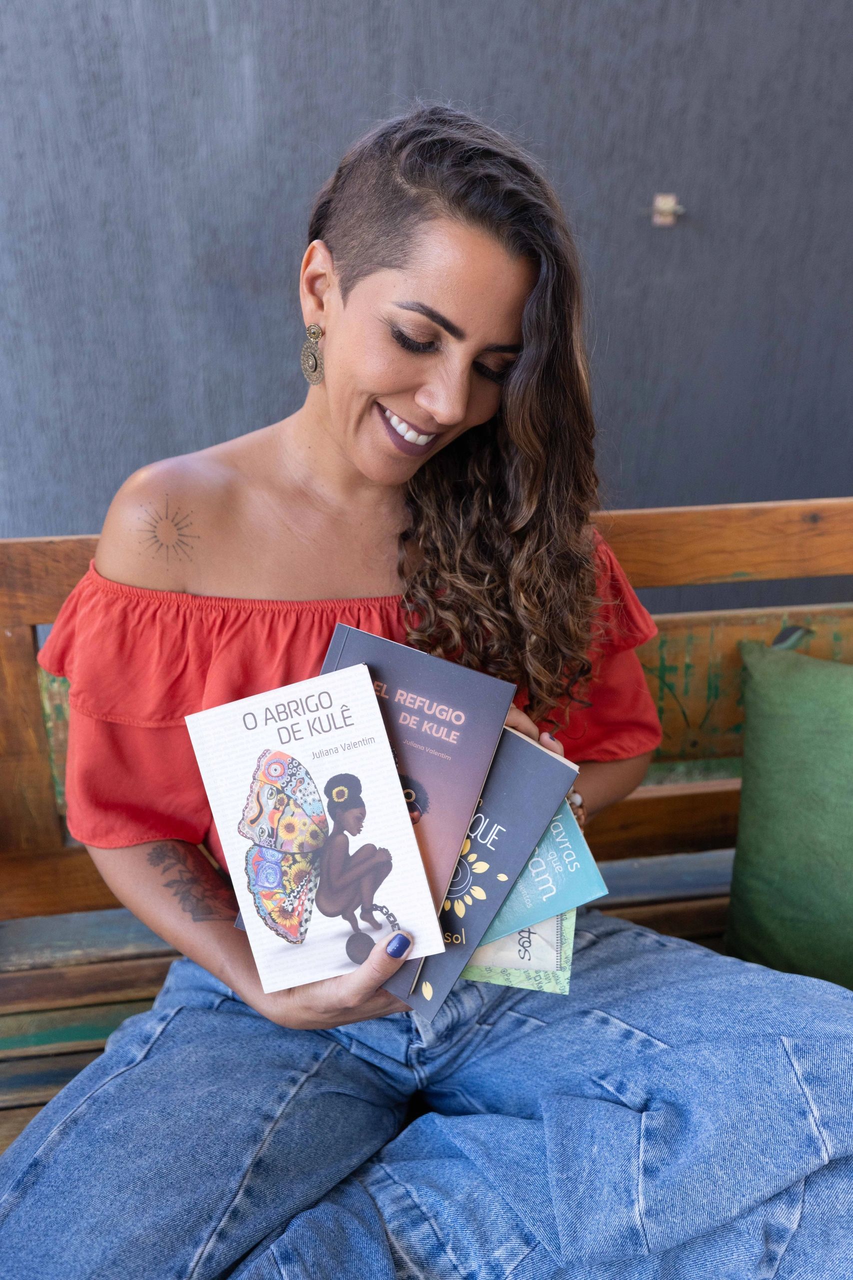 Juliana Valentim segura livros. Fotos de Thaís Mallon.