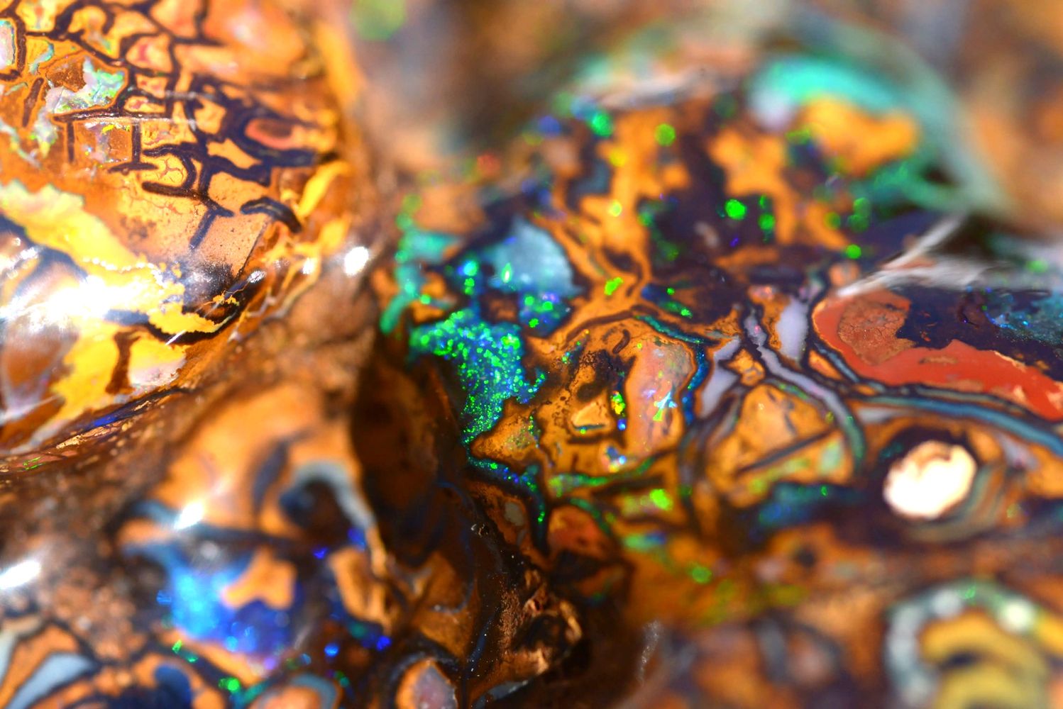 Close-up of colorful boulder opal with vibrant patterns and iridescent colors.