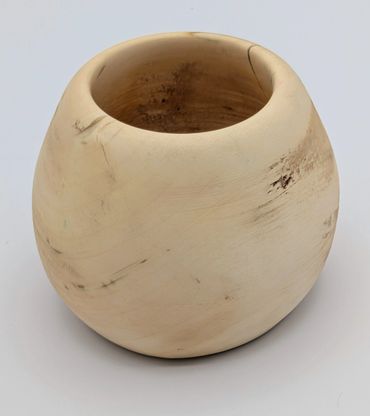 Hand-carved wooden bowl with natural cracks and grain patterns.