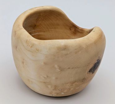 Smooth, rounded wooden bowl with natural grain and a carved opening.