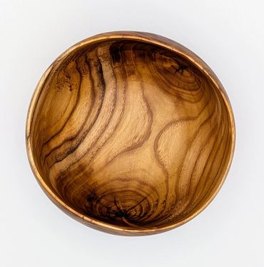A round wooden bowl with natural grain patterns on a white background.