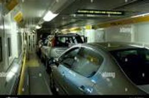 Cars lined up inside a car ferry's vehicle deck.