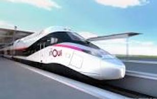 Modern high-speed train moving on tracks under a clear sky.