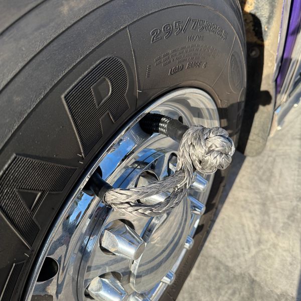 Rope tied through a wheel lug on a truck tire.