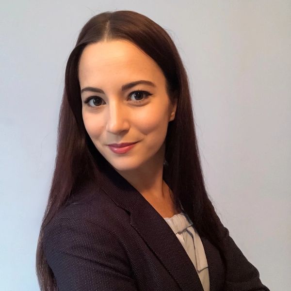 Confident woman with long brown hair in business attire.