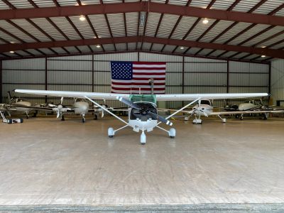 Small aircraft in a hangar with an American flag.