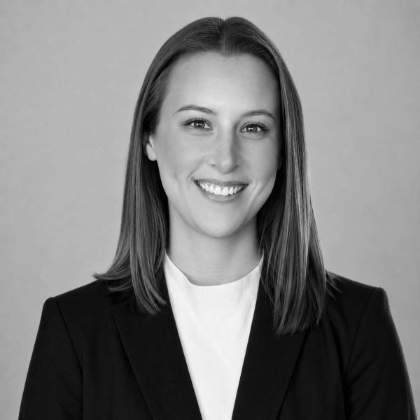 Professional black and white portrait of a smiling woman in business attire.