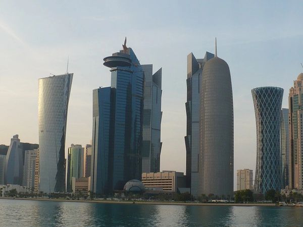 A waterfront view of the modern, unique skyscrapers of the Doha, Qatar skyline.