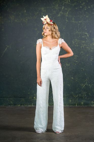 feminine bridal jumpsuit with flared legs, lace sleeves and low neckline.