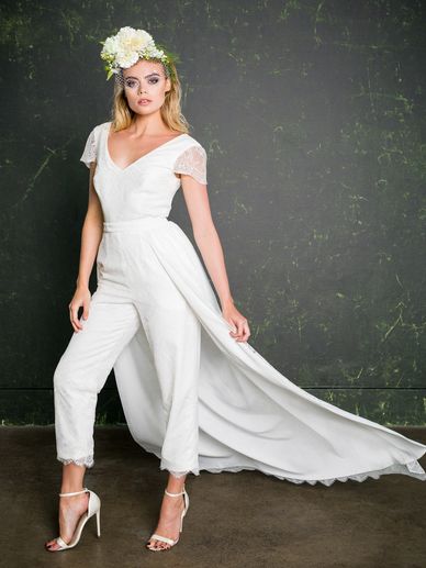 Lace bridal jumpsuit with cropped tailor trousers and capped sleeves with a removable over skirt