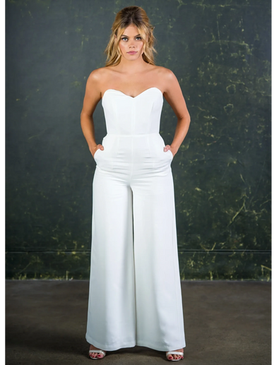 Strapless sweetheart neckline white bridal jumpsuit with pockets and wide leg trousers.