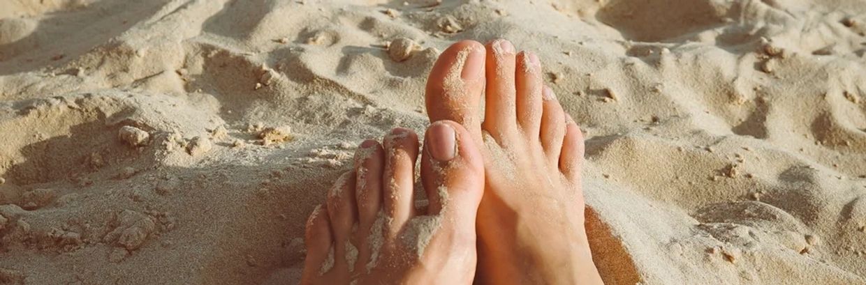 Vackra fötter på sanden