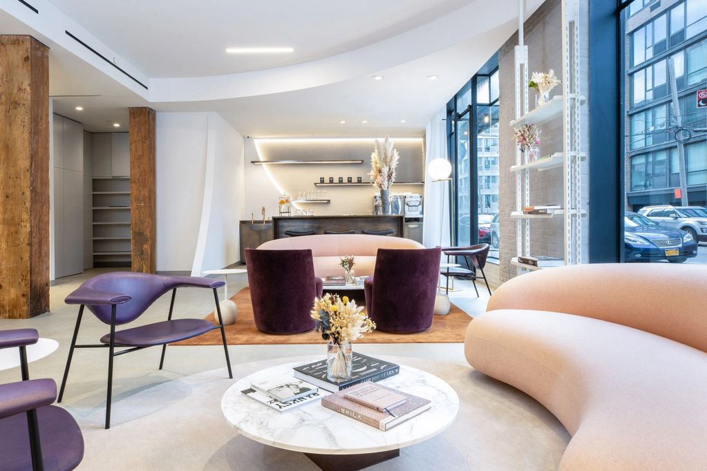 Modern lounge area with stylish purple chairs and curved peach sofa.