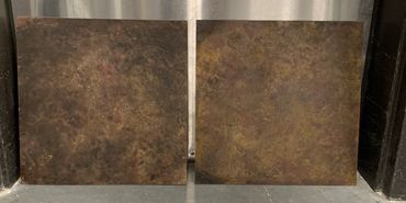 Two small square sheets of masonite are painted a muddy paint treatment.
