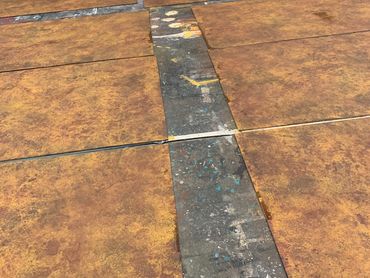 Sheets of masonite covered with a muddy paint treatment, but in the earlier stages and more yellow.