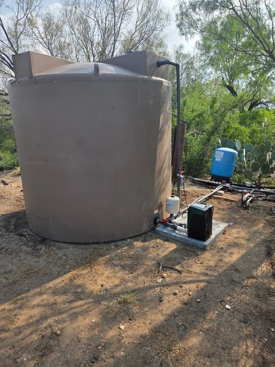 Residential water storage tank with booster pump system installed in Uvalde County, Texas.
