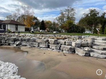 Retaining wall made out of armour stone, 3 layers, natural stone steps from the beach, stone
