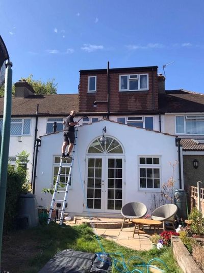Cleaning windows up a telescopic ladder