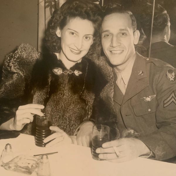 Vintage photo of a smiling couple, the man in military uniform and the woman in a fur coat.