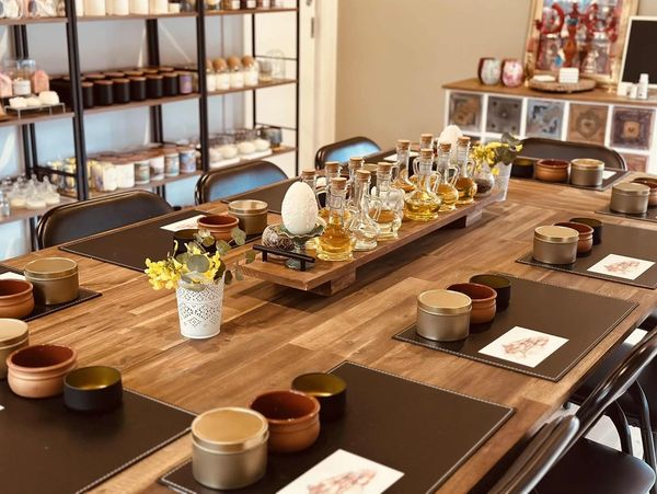 Elegant wooden table with various glass bottles and cozy dining setup.