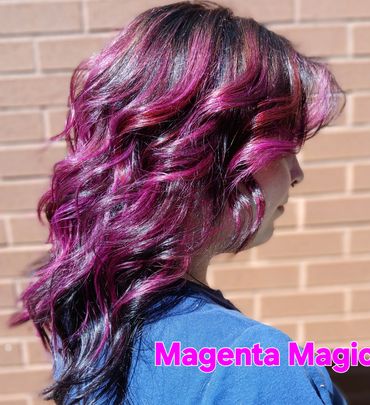 Woman with vibrant magenta and black wavy hair styled beautifully.