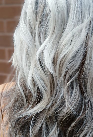 Long wavy hair with a mix of white and gray tones.