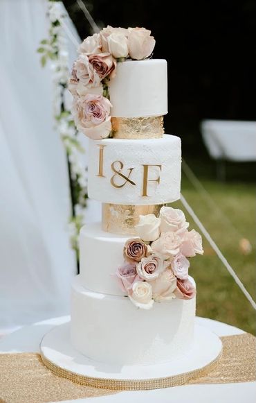 Six tiered Fondant wedding cake, with gold leafing, fresh florals and gold acrylic cake décor 