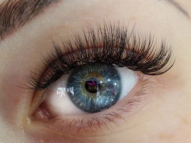 Full eyelash extensions shown on a model with blue eyes
