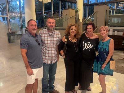 Group of five adults posing indoors.