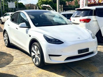 White Tesla Model Y parked outdoors.