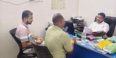 Advocate providing legal consultation to clients at the office regarding property and real estate ma