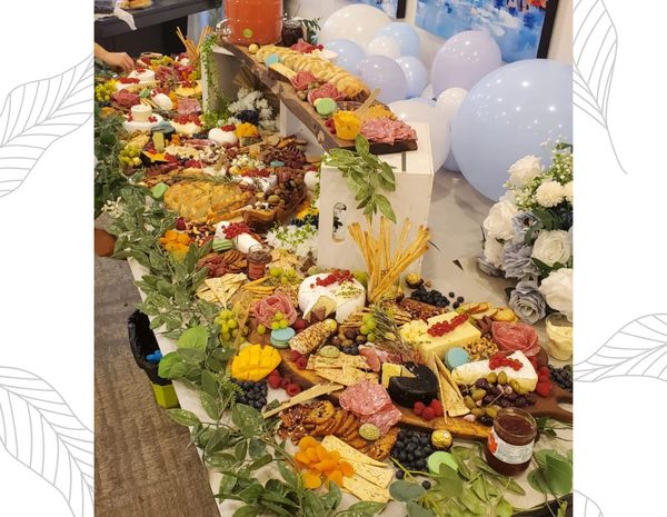 Grazing table of charcuterie, cheeses and crackers styled with balloons for a celebration