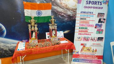 Trophies and medals displayed with Indian flag and sports banner.