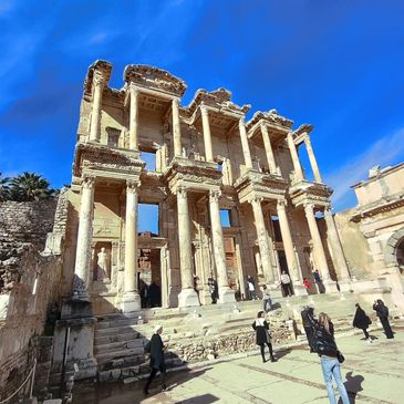 The ancient ruins of the Library of Celsus under a vivid blue sky.