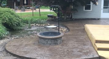 fire pit with smokeless steel insert, grill and ketlle wench on a stamped patio