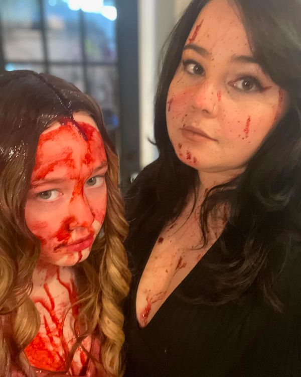 mother and daughter in Halloween costumes standing in front of window