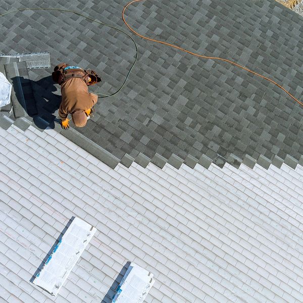 Roofer replacing the shingles of a home with Asphalt shingles