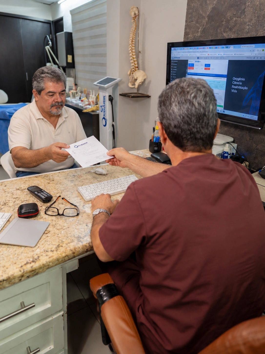 Consulta médica donde un paciente recibe un documento.