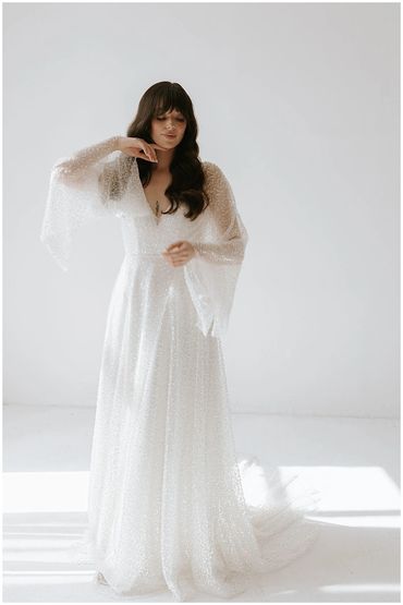 Storm. Sparkle dress with fluted bell sleeves and v neck worn with a maxi or mini slip underneath