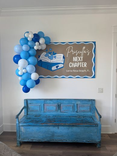 Blue-themed graduation decor with balloons and a rustic bench.
