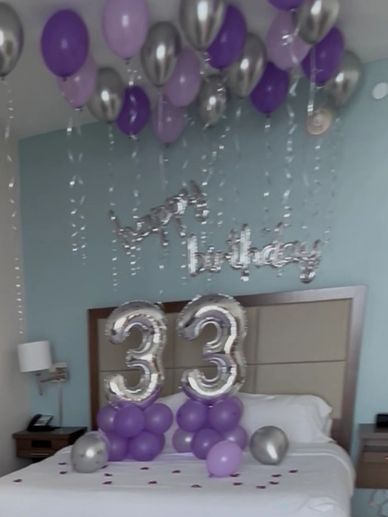 Birthday balloons and decorations celebrating 33 years on a bed.