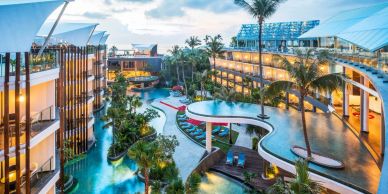 Modern resort with pools and palm trees.
