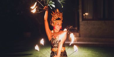 A woman performing a fire dance at night.