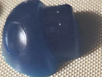 Close-up of a small blue object on a textured surface.