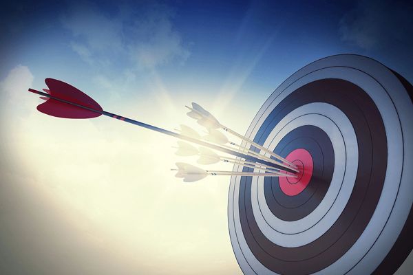 Arrows hitting the bullseye on a target against a bright sky.