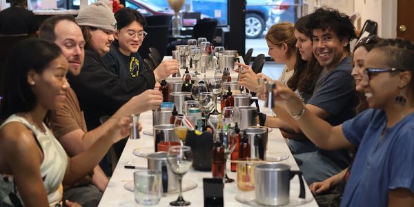 A diverse group enjoying drinks together at a long bar counter.