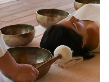Person resting during a sound therapy session with singing bowls.