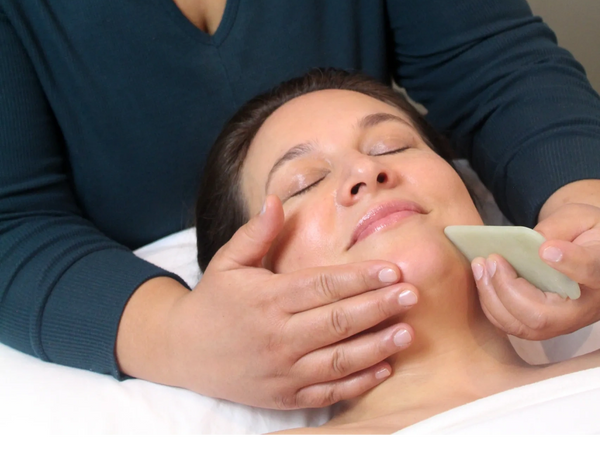 Registered Acupuncturist using facial gua sha on face to release tension.  Kiran Schaffer Registered