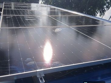 Solar panels reflecting sunlight with a feather on top.