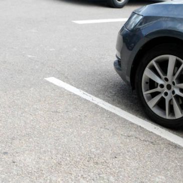 Close-up of a car front tire in a parking spot.